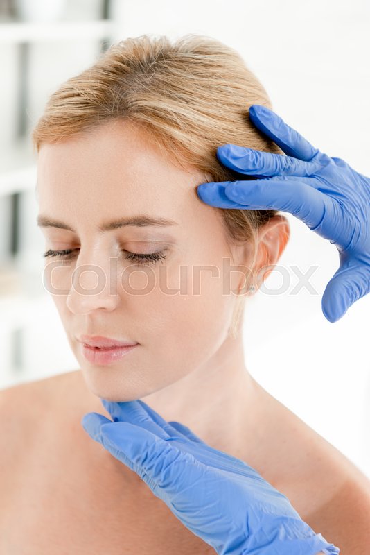 dermatologist examining white spots on patient's skin