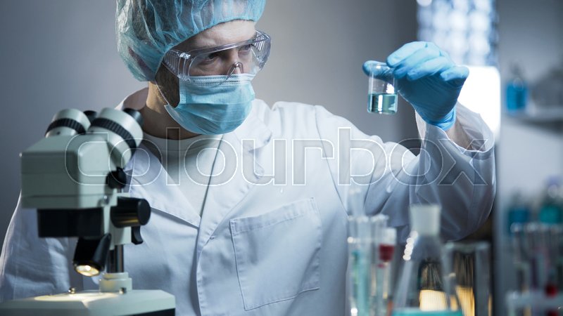Lab technician examining sample of ... | Stock image | Colourbox