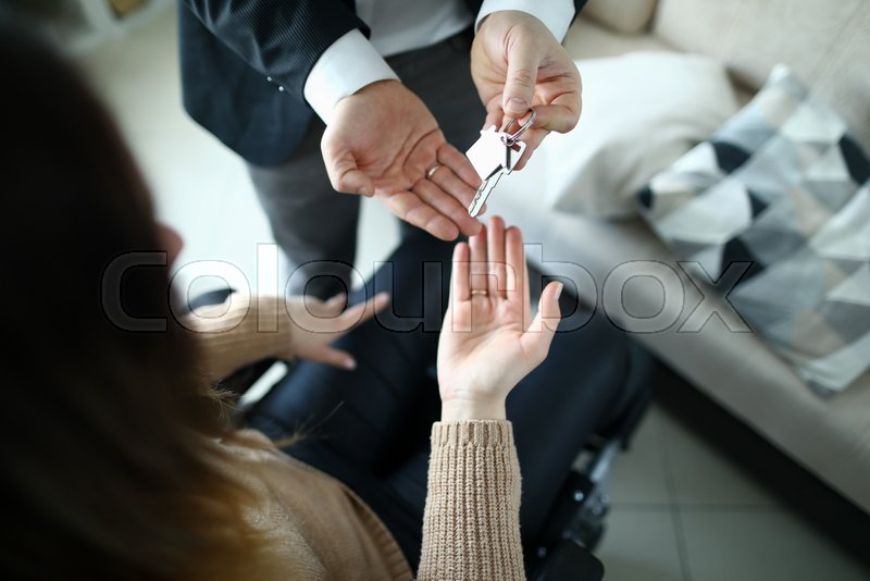Male businessman hand passes the key to Stock image Colourbox
