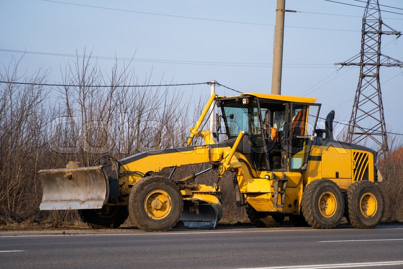 Grader is working on road construction. Stock image Colourbox