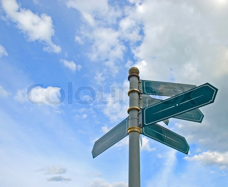 blank old directional road sign post over blue sky stock photo