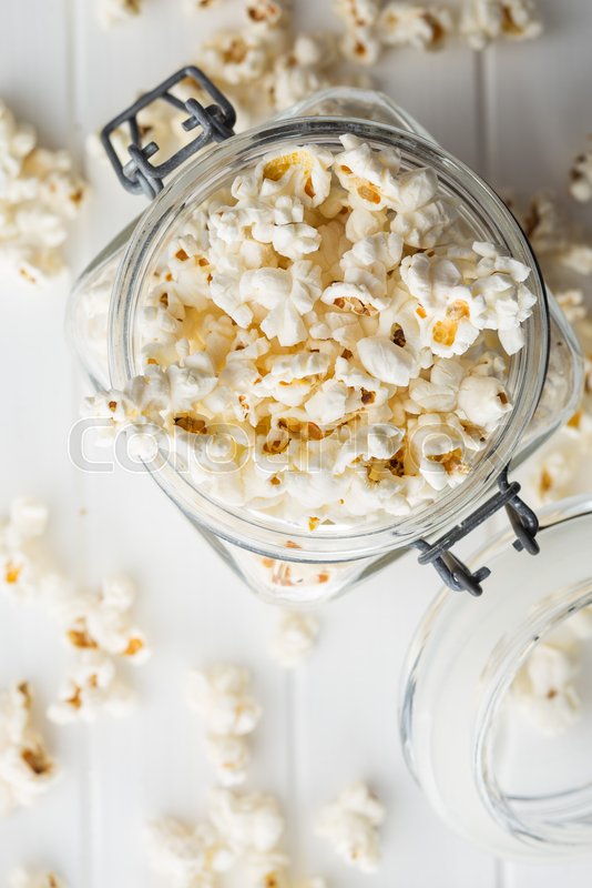 Popcorn in jar on white table. Stock image Colourbox
