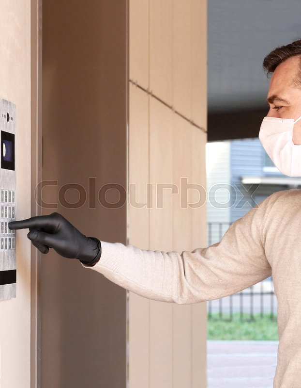 Man in face mask and gloves dials the Stock image Colourbox