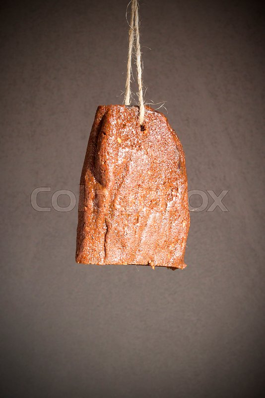 Jerky beef hanging on a rope against a Stock image Colourbox