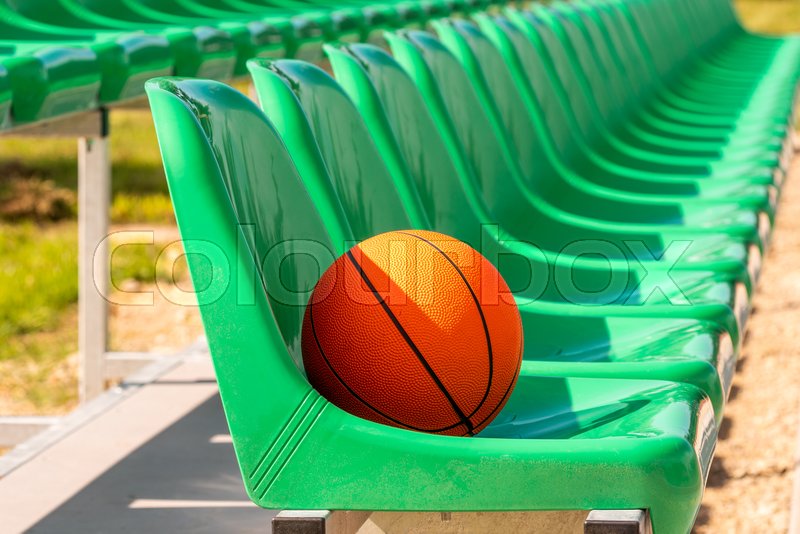 Line of stadium chairs with an orange Stock image Colourbox