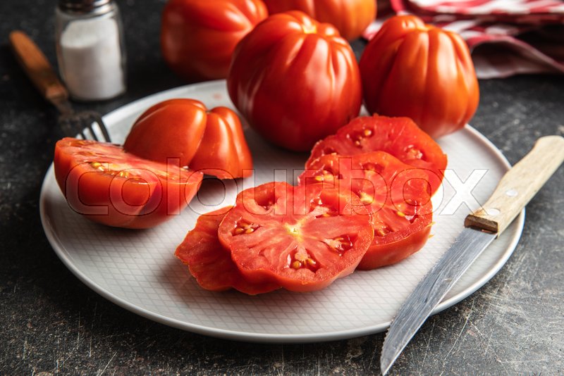Red beefsteak tomatoes on plate. Stock image Colourbox