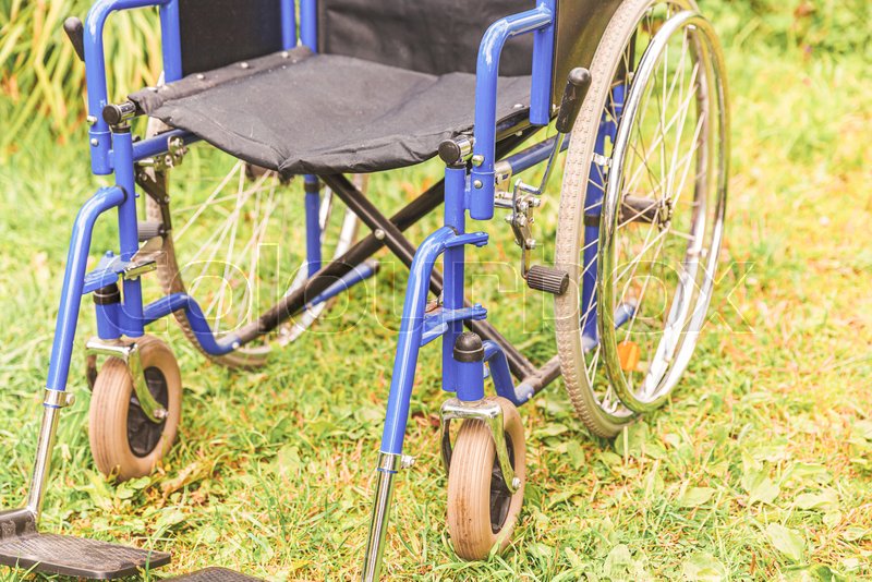 Empty wheelchair standing on grass in Stock image Colourbox