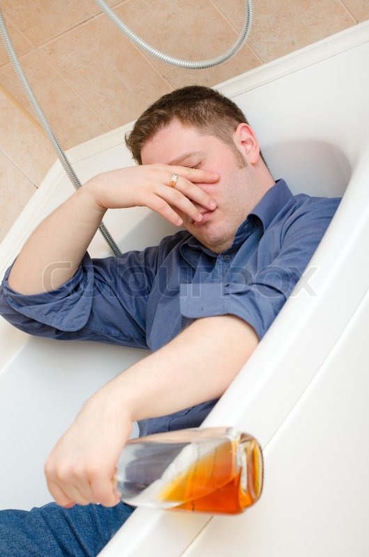 Drunk man with bottle lying in bath Stock image Colourbox