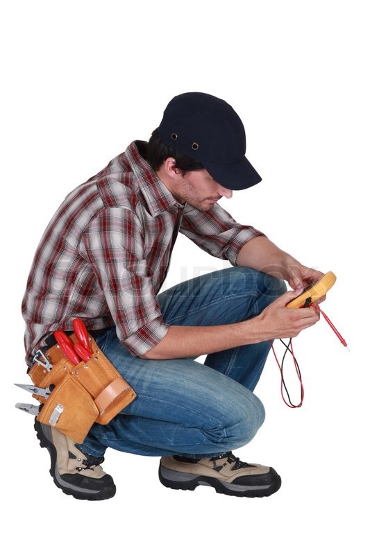 Kneeled electrician with a voltmeter. Stock image Colourbox