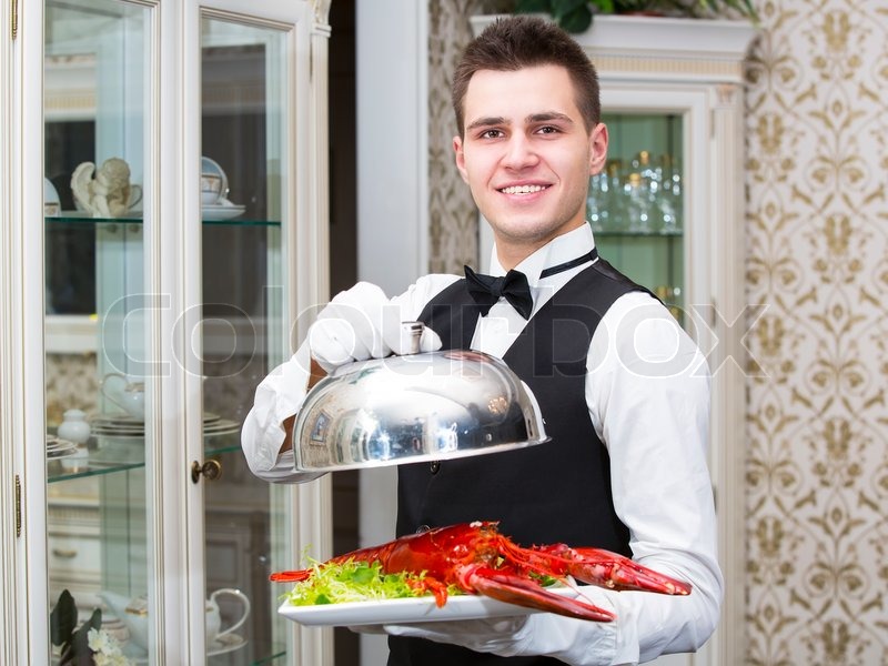 waiter with lobster on a plate in a restaurant stock photo colourbox