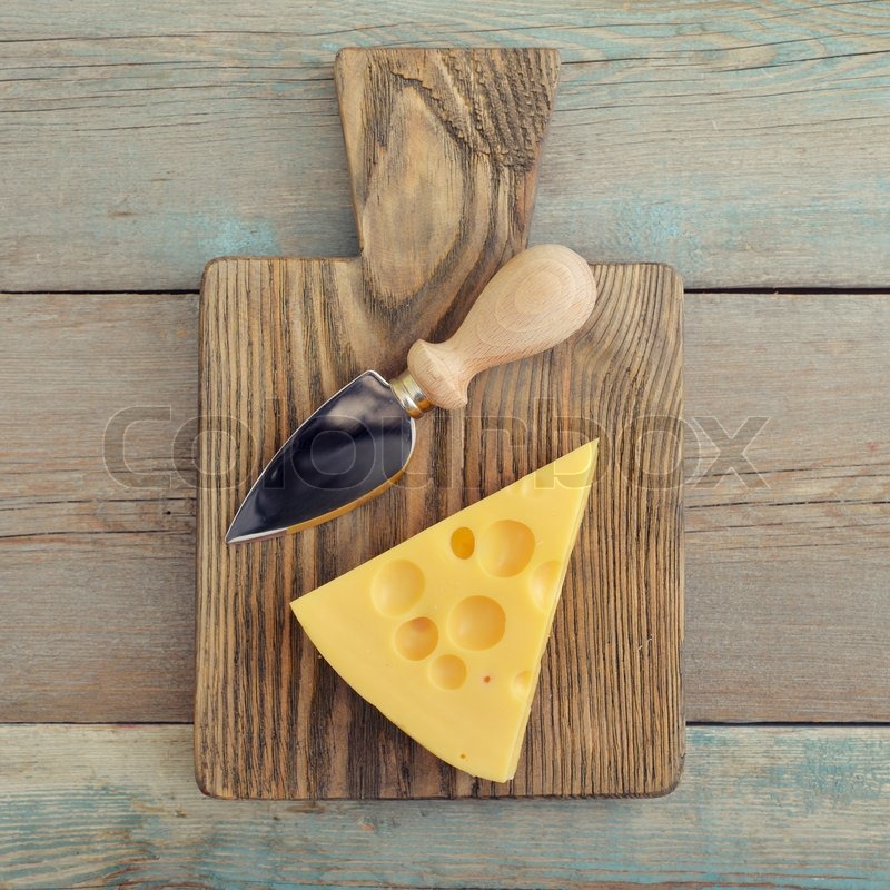 Cheese with big holes and knife on Stock image Colourbox