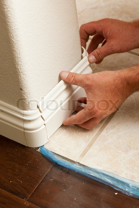 Contractor Installing New Baseboard With Bull Nose Corners And Contractor Installing New Baseboard With Bull Nose Corners And Laminate Flooring Renovation Abstract Stock Photo Colourbox